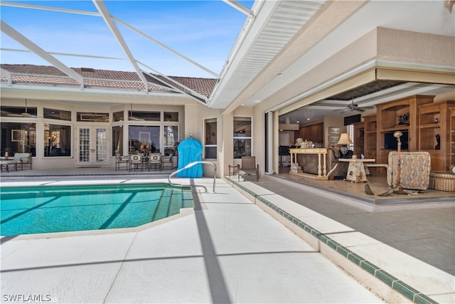 view of swimming pool with a patio area, ceiling fan, french doors, and glass enclosure