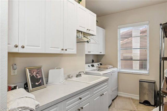 laundry area with cabinets, light tile flooring, washer and dryer, and sink