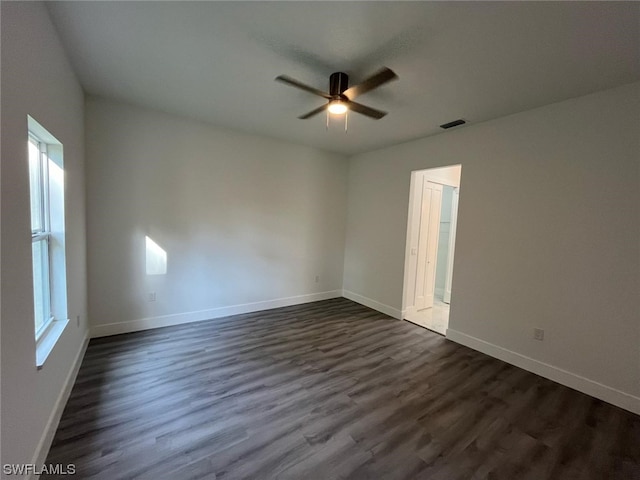 unfurnished room with a wealth of natural light, ceiling fan, and dark hardwood / wood-style flooring