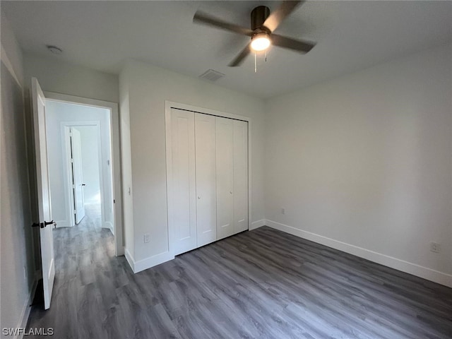 unfurnished bedroom featuring a closet, dark hardwood / wood-style floors, and ceiling fan