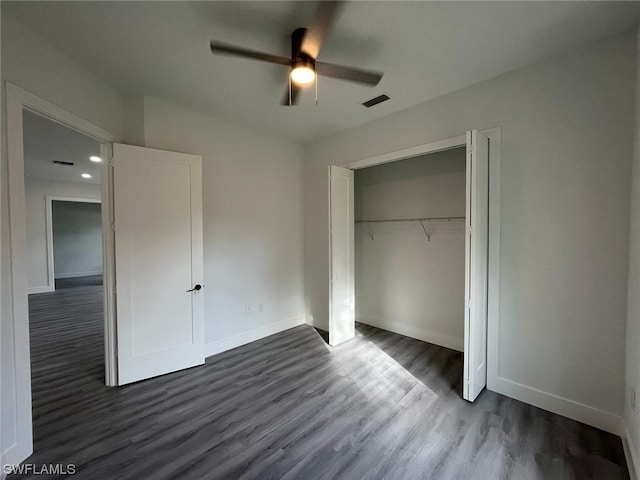 unfurnished bedroom with dark hardwood / wood-style flooring, a closet, and ceiling fan