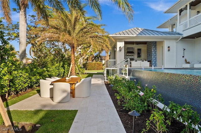 view of patio / terrace with pool water feature, a balcony, and ceiling fan