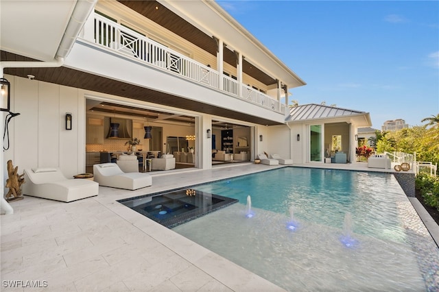 view of swimming pool with a patio area, an in ground hot tub, and pool water feature