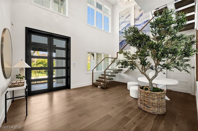 foyer featuring dark hardwood / wood-style flooring, french doors, and a towering ceiling