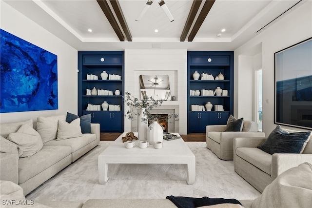 living room featuring a fireplace, beam ceiling, light hardwood / wood-style floors, and built in features