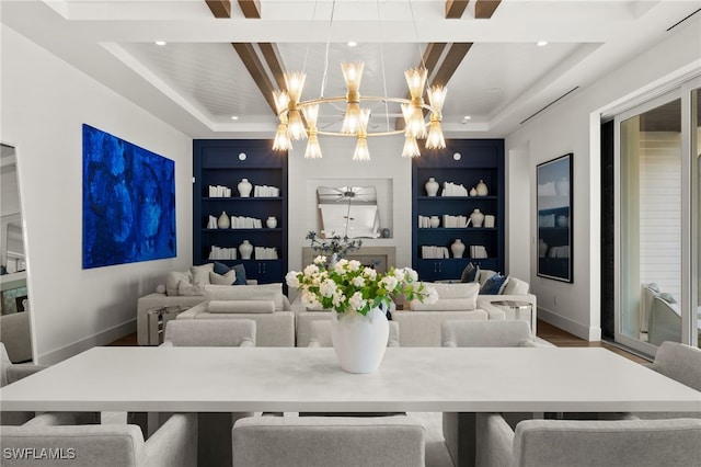 dining room with hardwood / wood-style floors, a tray ceiling, built in shelves, and a notable chandelier