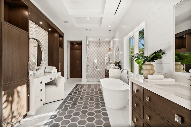 bathroom with a raised ceiling, separate shower and tub, and vanity