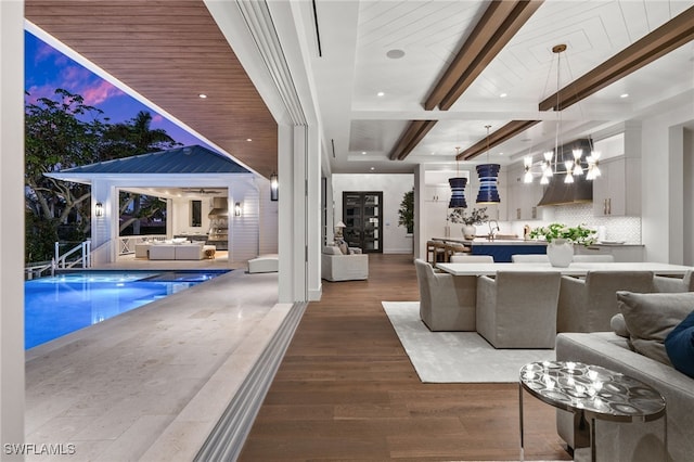 living room featuring beamed ceiling and dark hardwood / wood-style floors