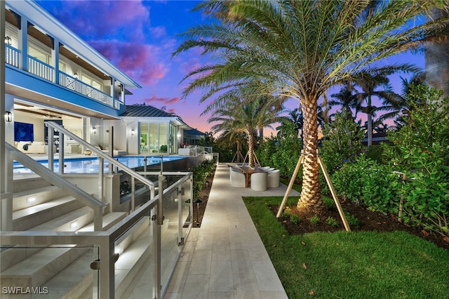 pool at dusk featuring a patio