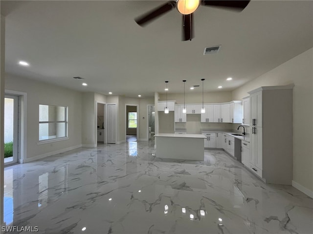 kitchen featuring ceiling fan, decorative light fixtures, a kitchen island, light tile floors, and white cabinetry