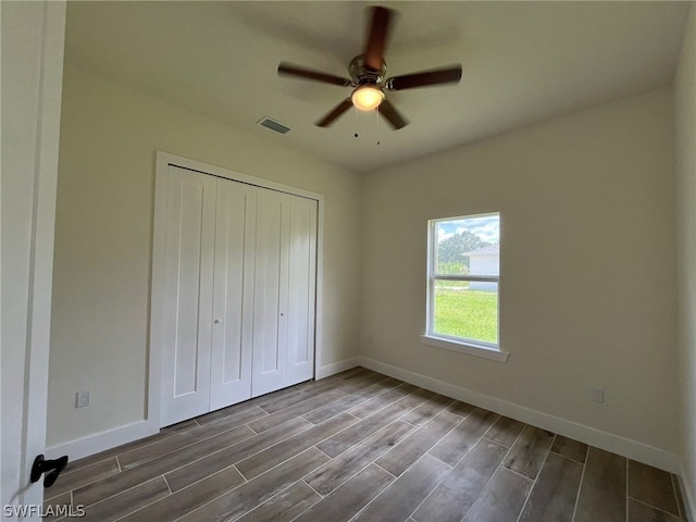 unfurnished bedroom with a closet, ceiling fan, and dark hardwood / wood-style flooring