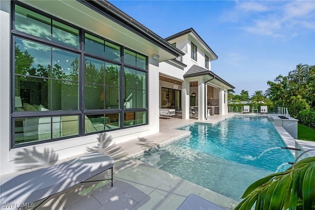 view of swimming pool featuring pool water feature and a patio