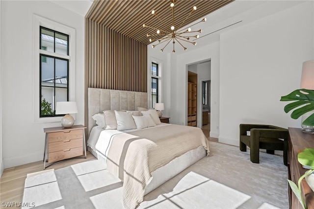 bedroom with light hardwood / wood-style floors, wooden ceiling, and an inviting chandelier