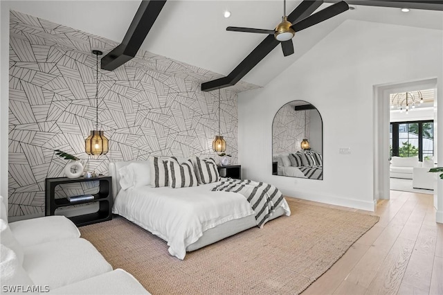 bedroom with high vaulted ceiling, ceiling fan with notable chandelier, light hardwood / wood-style floors, tile walls, and beam ceiling