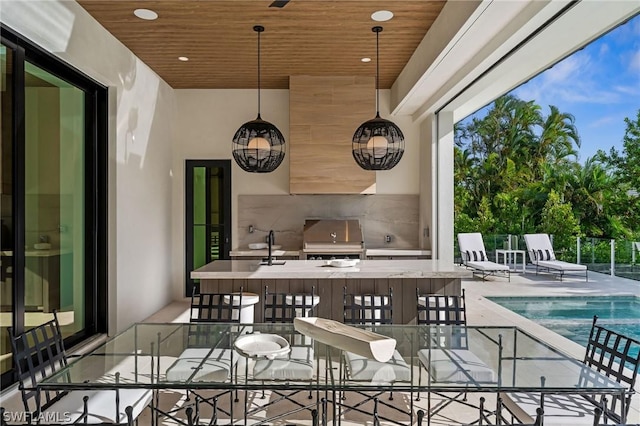 view of patio with an outdoor kitchen, ceiling fan, and a grill