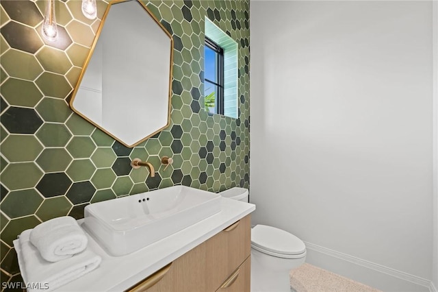 bathroom with vanity, toilet, and tile walls