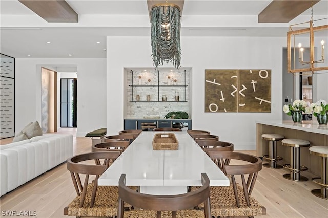 dining space featuring light wood-type flooring and an inviting chandelier