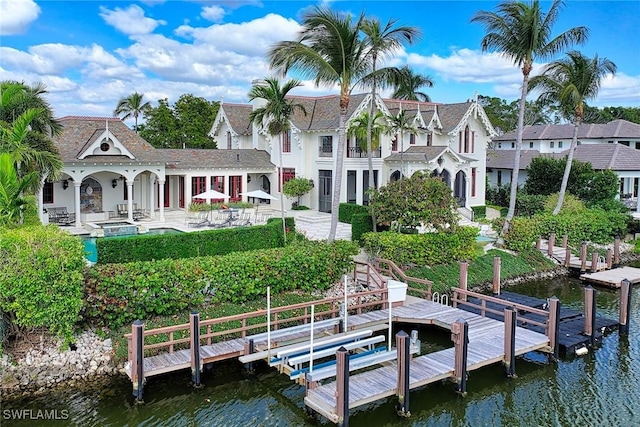 back of house featuring a water view and a patio