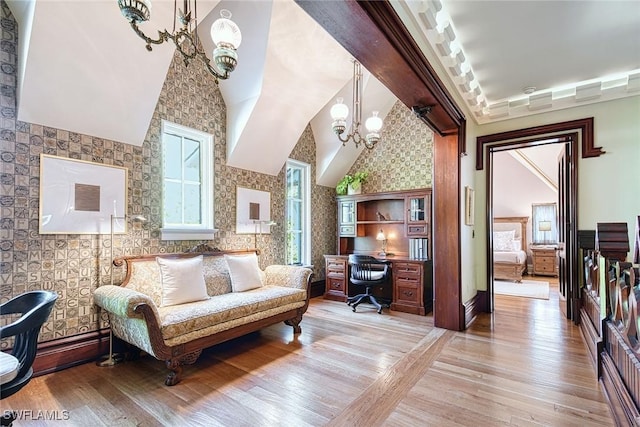 office area featuring an inviting chandelier, vaulted ceiling, and light wood-type flooring