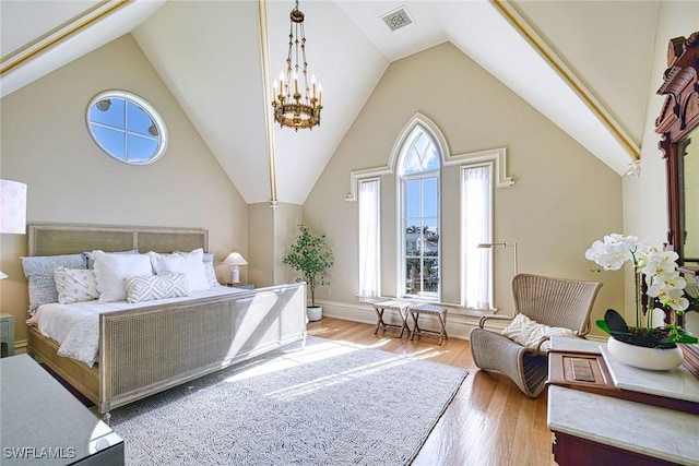 bedroom featuring a notable chandelier, high vaulted ceiling, and light hardwood / wood-style flooring