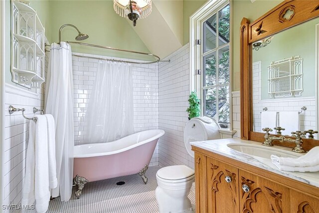 full bathroom with tile walls, vanity, toilet, shower / bath combo, and tile patterned floors