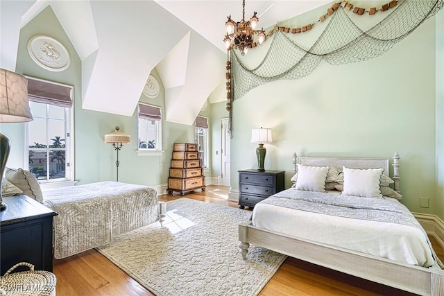 bedroom featuring a towering ceiling, wood-type flooring, and a chandelier