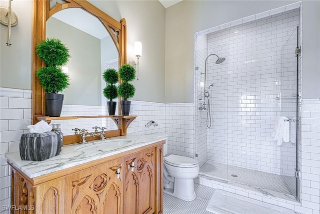 bathroom with a shower with shower door, tile walls, tile patterned flooring, vanity, and toilet