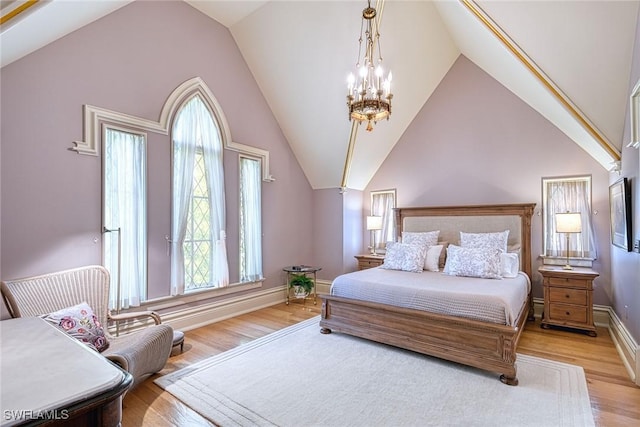 bedroom featuring multiple windows, high vaulted ceiling, a chandelier, and light wood-type flooring