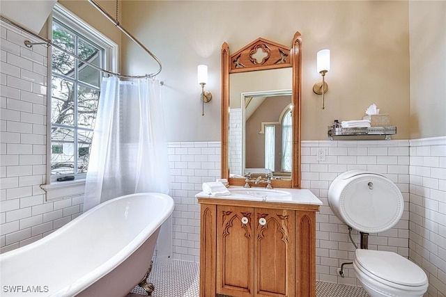 full bathroom with tile walls, vanity, and tile patterned flooring