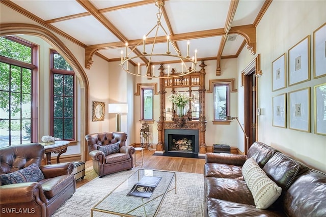 living room featuring wood-type flooring, a chandelier, ornamental molding, coffered ceiling, and beam ceiling