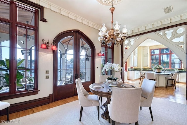 dining room featuring light hardwood / wood-style flooring, a chandelier, and french doors