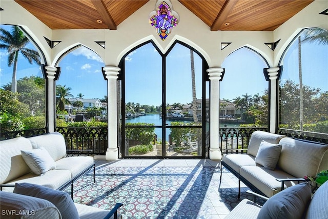 sunroom / solarium featuring a water view, lofted ceiling, decorative columns, and wooden ceiling