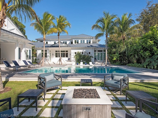 view of swimming pool featuring a patio area and a fire pit