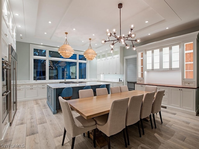 dining area with a chandelier and light hardwood / wood-style flooring