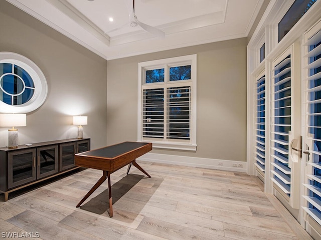 office featuring light wood-type flooring, a tray ceiling, and ornamental molding