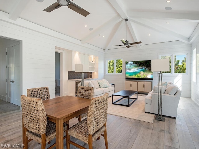 dining space with vaulted ceiling with beams, a wealth of natural light, ceiling fan, and light wood-type flooring