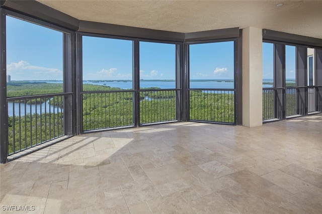 unfurnished sunroom with a water view and a wealth of natural light