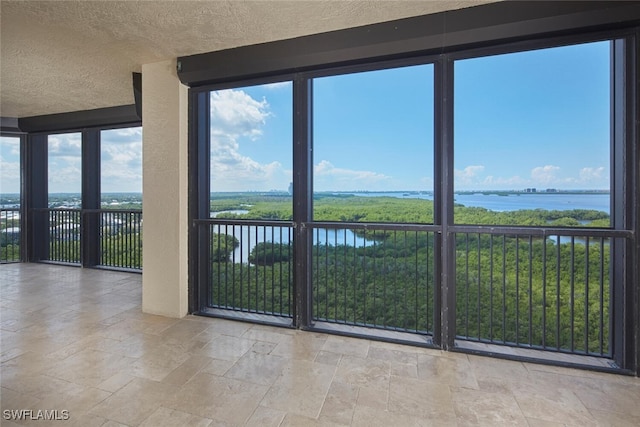 interior space with a textured ceiling and a water view