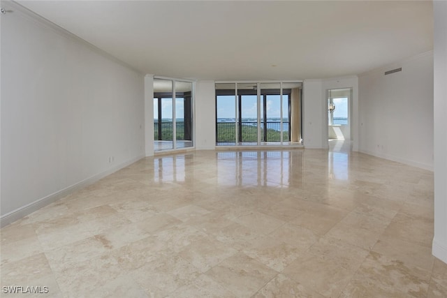 unfurnished room with crown molding and a wealth of natural light