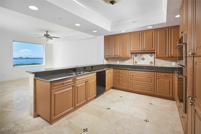 kitchen featuring a tray ceiling, kitchen peninsula, black appliances, crown molding, and ceiling fan