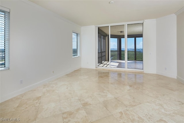 unfurnished room featuring crown molding and a wealth of natural light