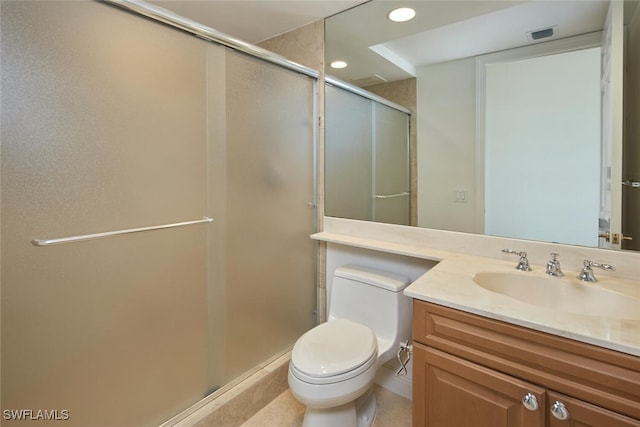 bathroom featuring tile patterned floors, a shower with door, vanity, and toilet