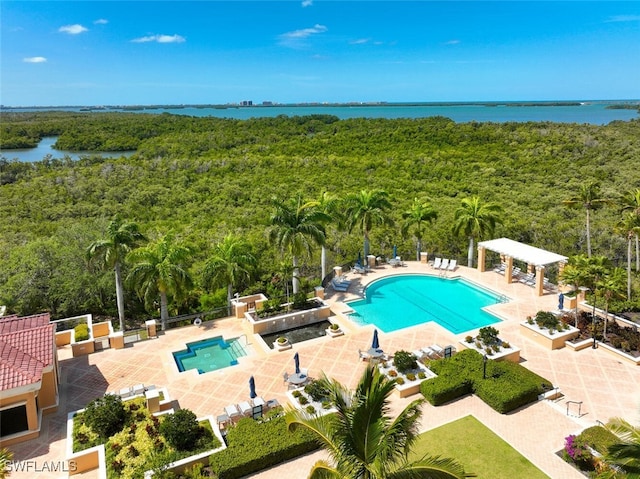 view of swimming pool featuring a water view and a patio area