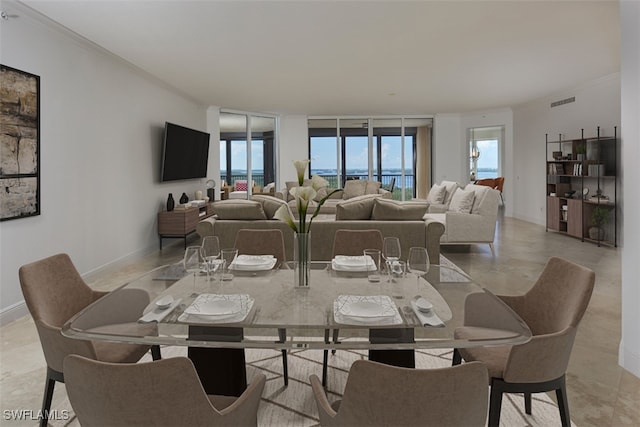 dining room featuring crown molding, light tile patterned floors, and a wealth of natural light