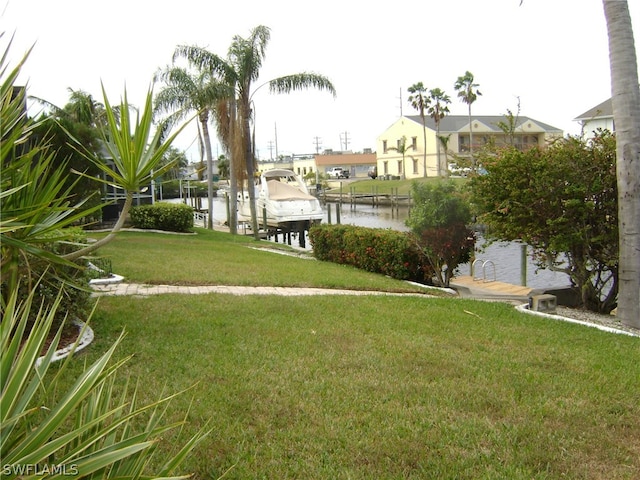 view of yard with a dock and a water view