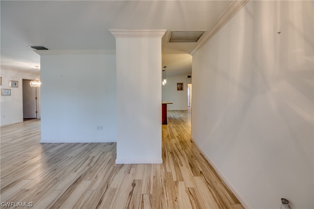 empty room featuring a chandelier, ornamental molding, and light hardwood / wood-style floors