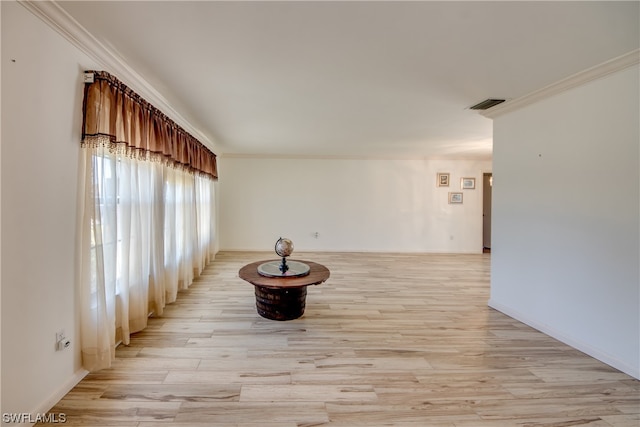 unfurnished room featuring crown molding and light wood-type flooring