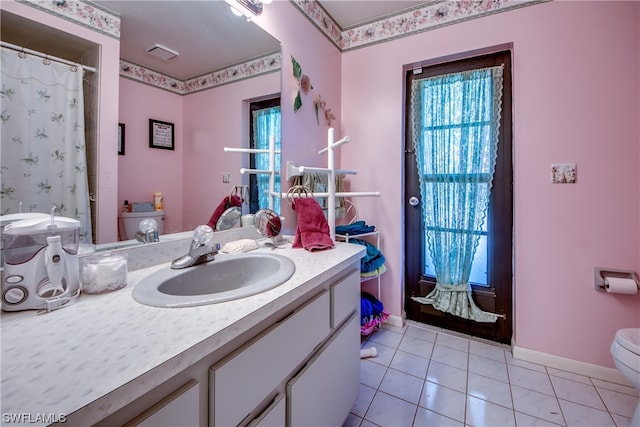 bathroom featuring tile floors, oversized vanity, and toilet