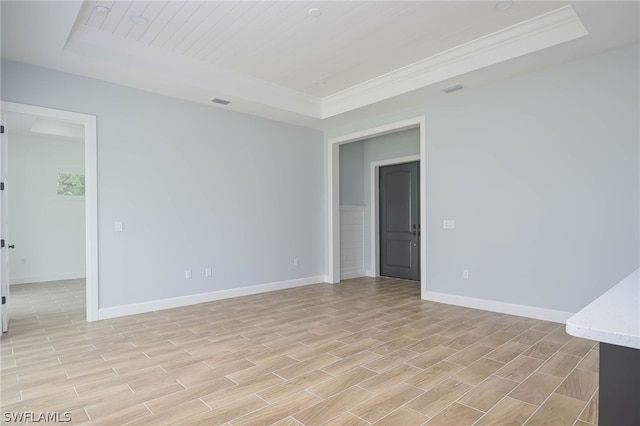 unfurnished room featuring a tray ceiling and crown molding