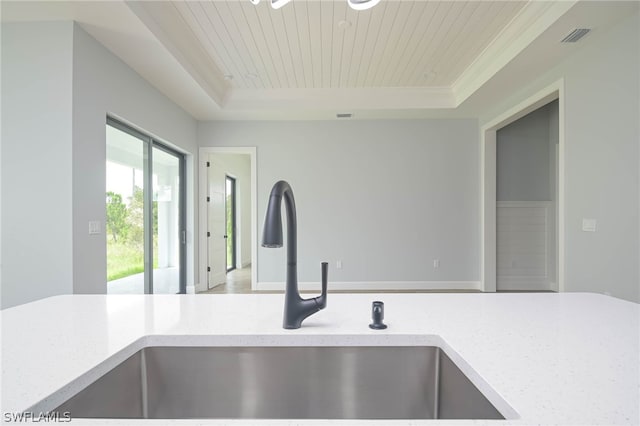 room details featuring light stone counters, wooden ceiling, sink, and a tray ceiling